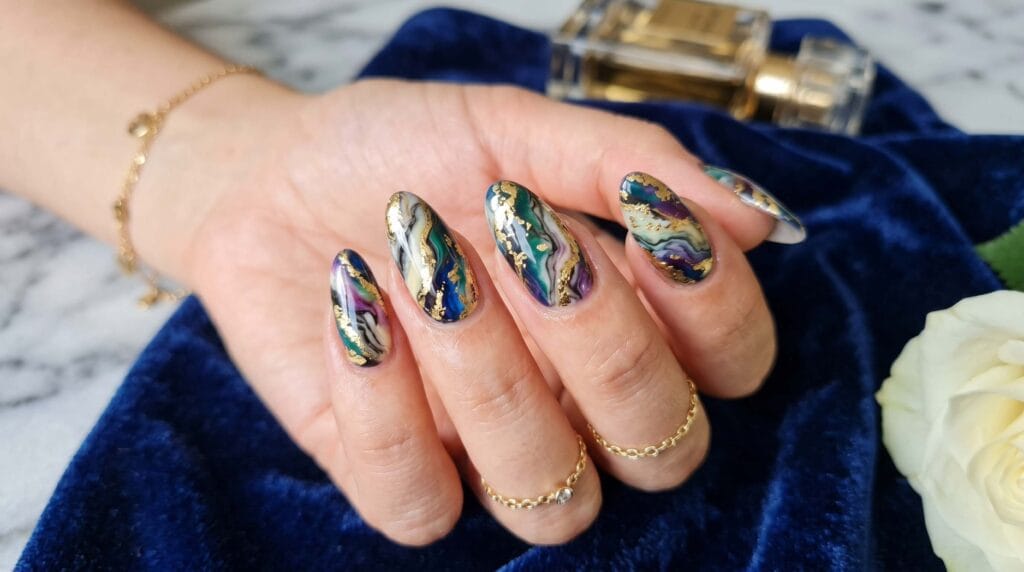 Close-up of luxury multicolor marble nails featuring flowing marble patterns, glossy finish, and a refined artistic manicure style.