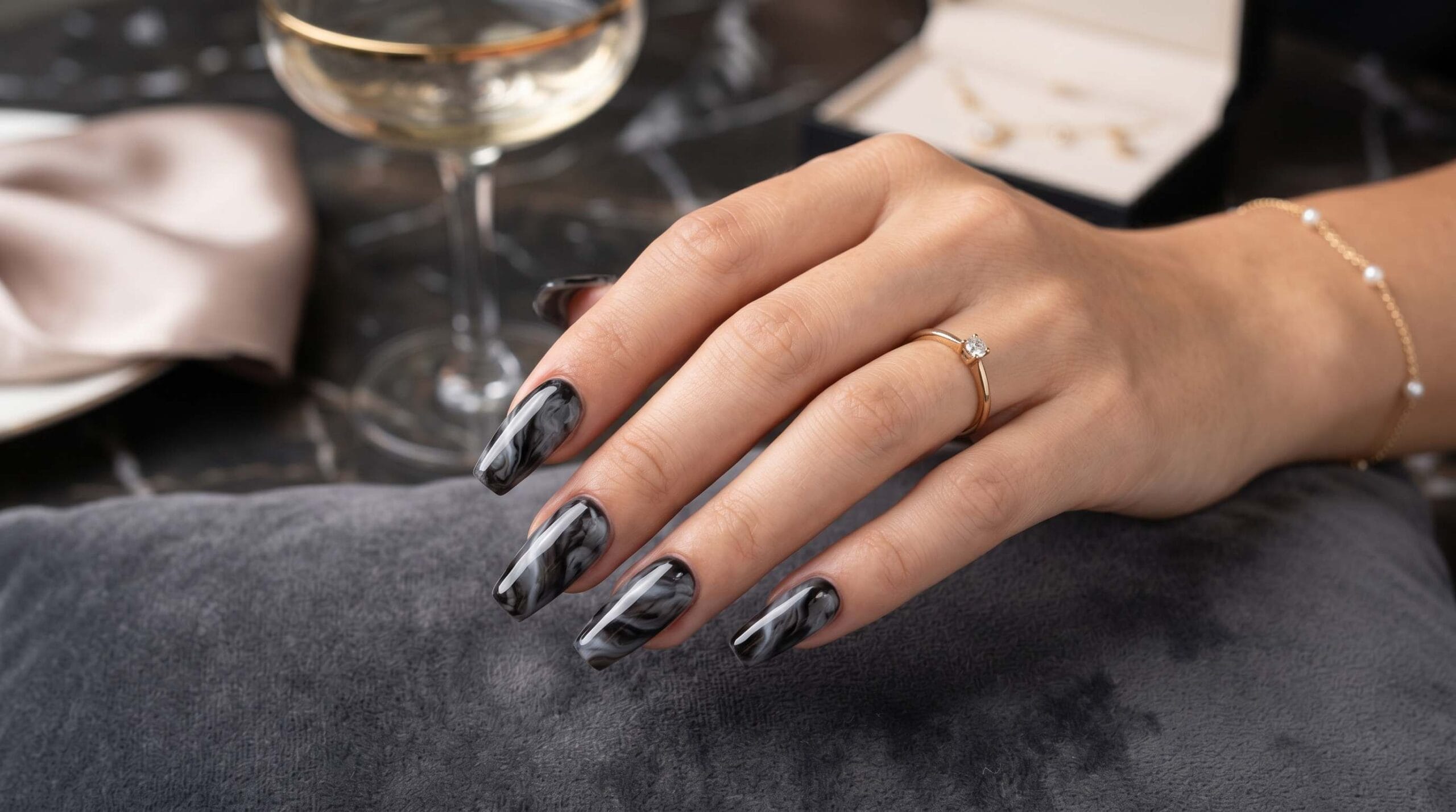 Close-up of smoky black marble nail art featuring soft flowing patterns with a glossy luxury manicure finish.